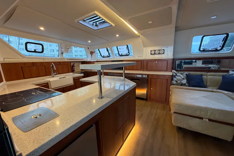 Calacoto Yacht Photos Pics Luxurious interior of 2023 Royal Cape Catamarans Majestic 530 with modern kitchen and seating area.