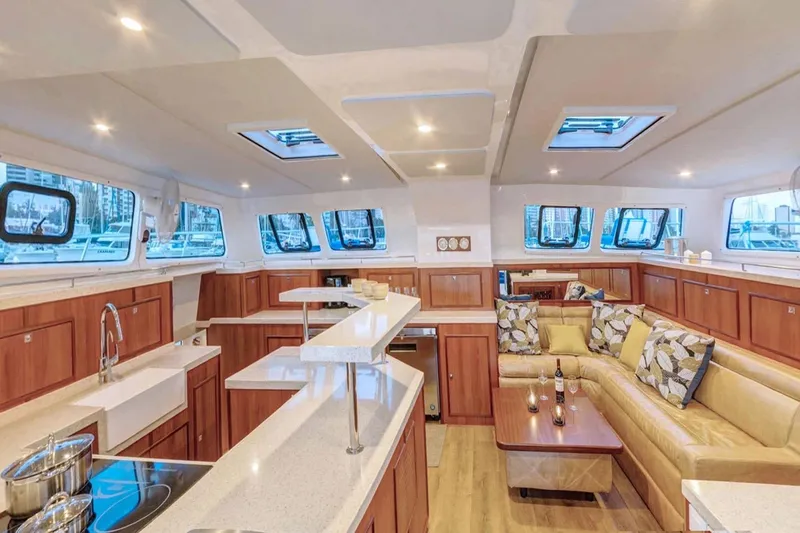 Calacoto Yacht Photos Pics Luxurious interior of 2023 Royal Cape Catamarans Majestic 530 with modern kitchen and seating area.