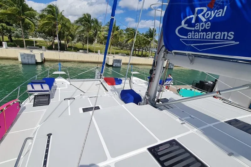 Calacoto Yacht Photos Pics 2023 Royal Cape Catamarans Majestic 530 docked, featuring spacious deck and vibrant sail.