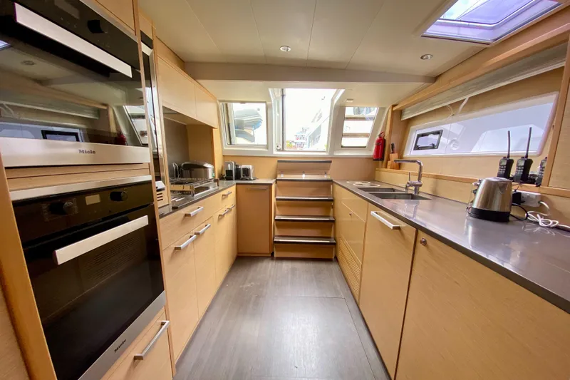  Yacht Photos Pics Modern kitchen interior on 2017 Lagoon 630 Motor Yacht, featuring sleek cabinetry and appliances.