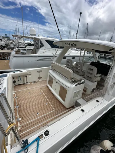  Yacht Photos Pics 2015 Boston Whaler 420 Outrage docked, featuring spacious deck and seating under cloudy sky.