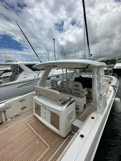  Yacht Photos Pics 2015 Boston Whaler 420 Outrage docked, showcasing spacious deck and seating under cloudy sky.