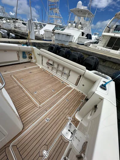  Yacht Photos Pics 2015 Boston Whaler 420 Outrage boat deck with wooden flooring, docked at a marina.