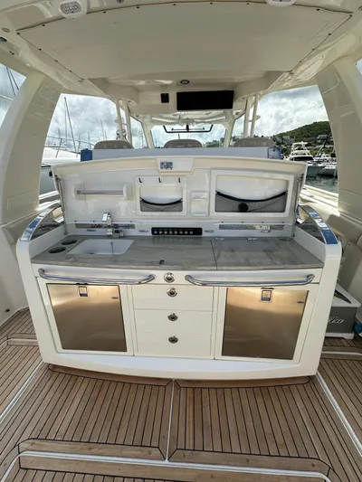  Yacht Photos Pics 2015 Boston Whaler 420 Outrage boat kitchen with sink, storage, and stainless steel appliances.