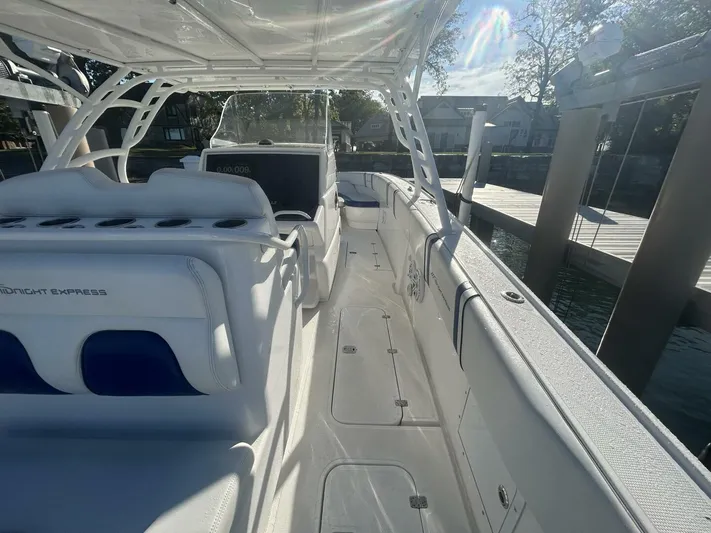  Yacht Photos Pics 2016 Midnight Express 37 Open boat interior with white seating and console, docked by the water.