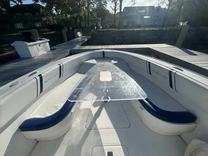  Yacht Photos Pics 2016 Midnight Express 37 Open boat interior with seating and table, docked by a waterfront.