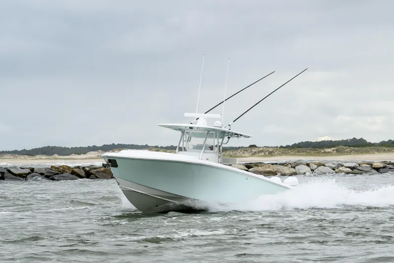 Comeback Yacht Photos Pics 2008 Venture 39 Cuddy boat navigating through waves near rocky shoreline.