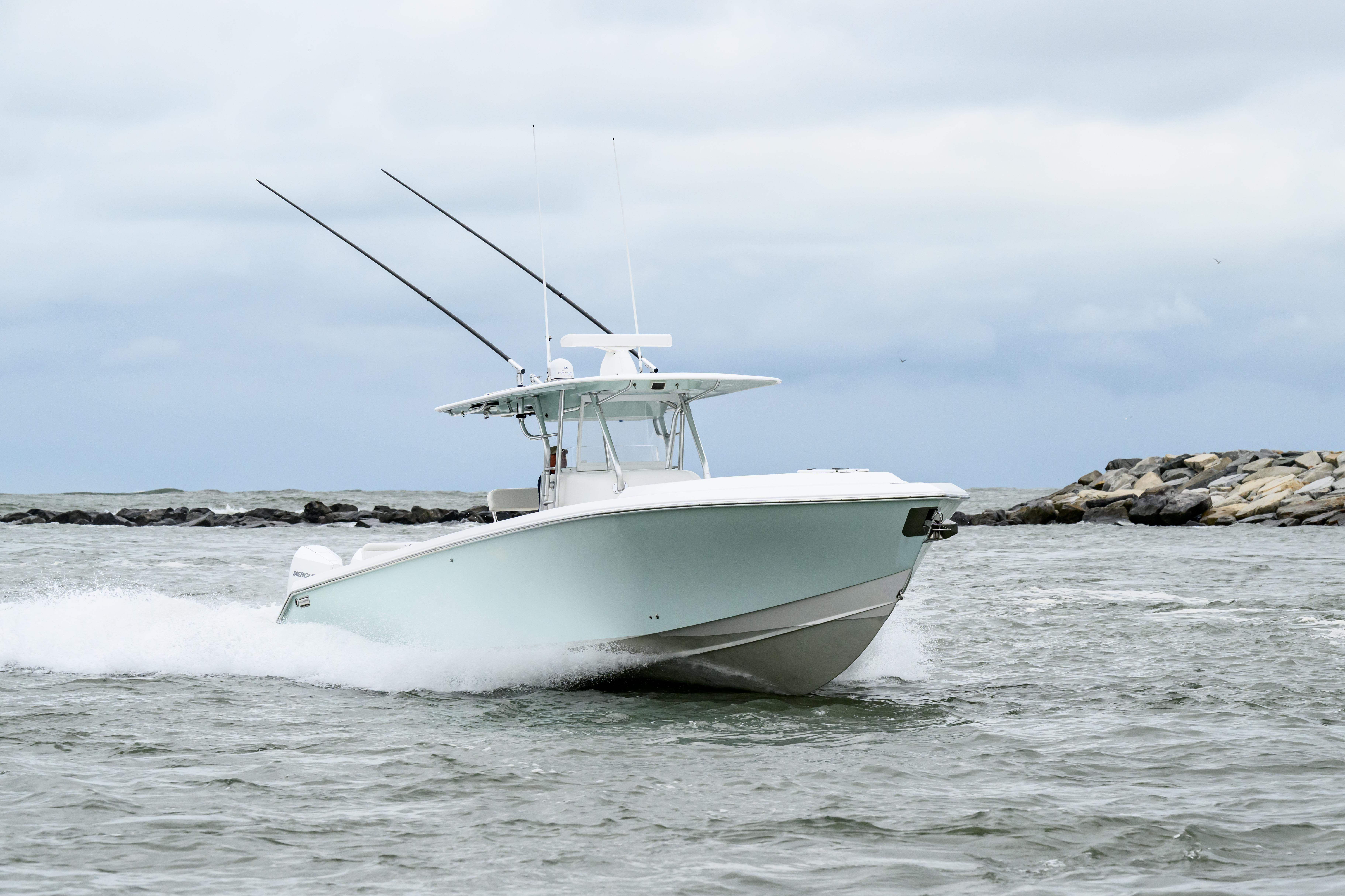 2008 Venture 39 Cuddy boat cruising on open water near rocky shoreline.