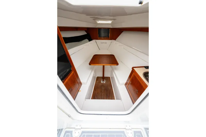 Comeback Yacht Photos Pics 2008 Venture 39 Cuddy interior with wood accents, seating, and compact table.