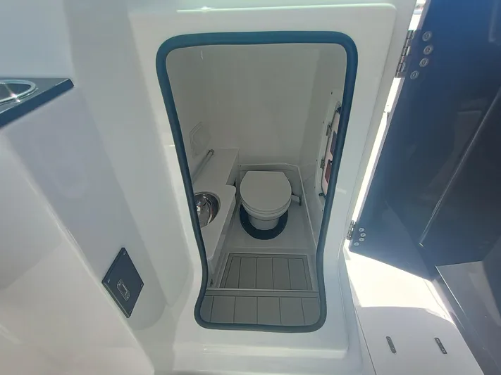  Yacht Photos Pics 2025 Blackfin 302 DC boat interior with compact marine toilet and sink.