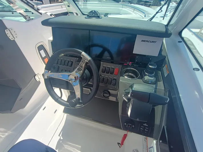  Yacht Photos Pics 2025 Blackfin 302 DC boat dashboard with steering wheel, controls, and Mercury display.