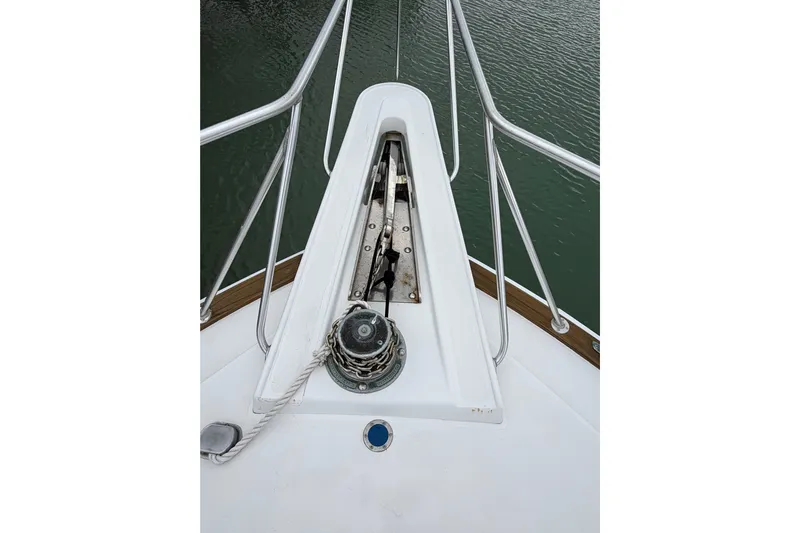 Pura Vida Yacht Photos Pics Bow of 1985 Bertram 54 Convertible yacht with anchor chain and railing.