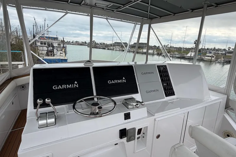 Pura Vida Yacht Photos Pics 1985 Bertram 54 Convertible yacht helm with Garmin navigation, overlooking marina.