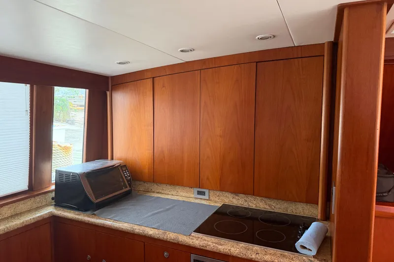 Pura Vida Yacht Photos Pics 1985 Bertram 54 Convertible yacht kitchen with wood cabinets and modern appliances.