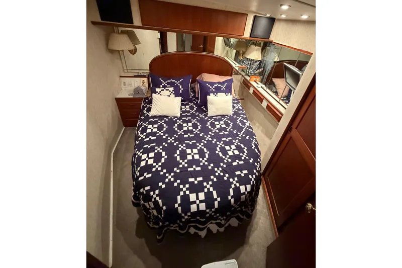 Pura Vida Yacht Photos Pics Cozy bedroom in 1985 Bertram 54 Convertible yacht with patterned bedding and wood accents.