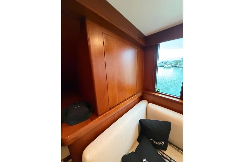 Pura Vida Yacht Photos Pics Interior of 1985 Bertram 54 Convertible yacht with wooden paneling and waterfront view.