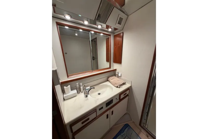 Pura Vida Yacht Photos Pics Bathroom vanity in 1985 Bertram 54 Convertible yacht, featuring mirror and sink.