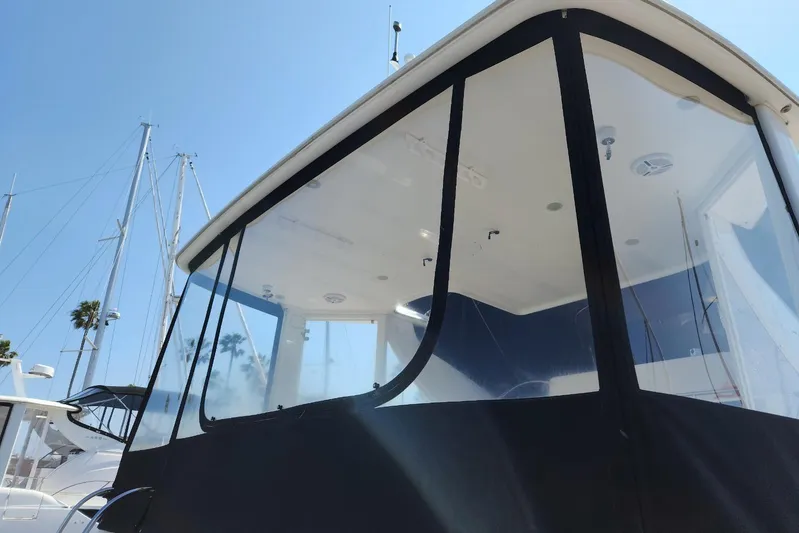 Embracing Life Yacht Photos Pics 2004 Meridian 459 Motoryacht with clear enclosure, docked under a sunny sky.