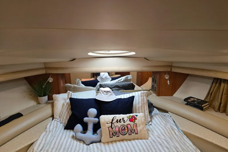Embracing Life Yacht Photos Pics Cozy bedroom interior of 2004 Meridian 459 Motoryacht with decorative pillows and books.