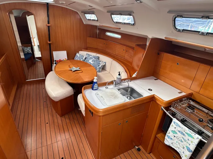 Pacifico Yacht Photos Pics Interior of 2005 Beneteau First 44.7 yacht with wood finish and cozy seating area.