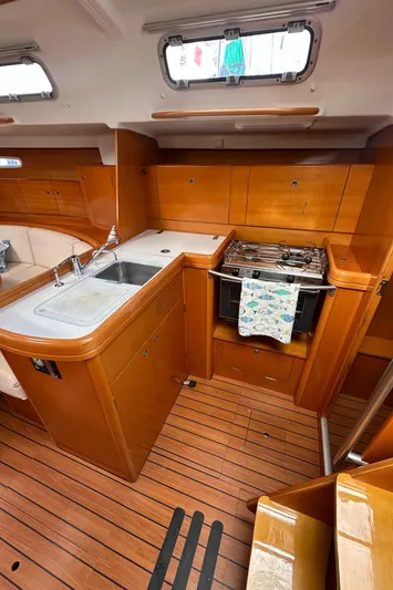 Pacifico Yacht Photos Pics 2005 Beneteau First 44.7 yacht kitchen with wood finish, sink, and stove.