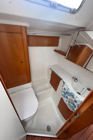 Pacifico Yacht Photos Pics Compact bathroom in 2005 Beneteau First 44.7 yacht with wood accents and modern fixtures.