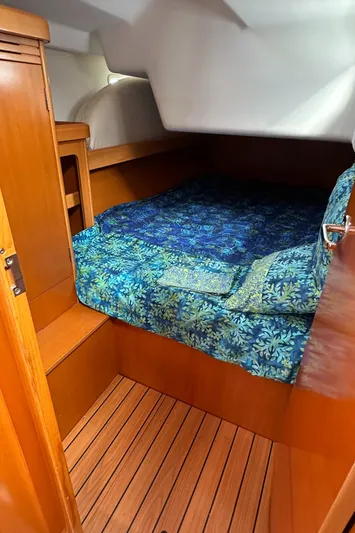 Pacifico Yacht Photos Pics Cozy cabin interior of 2005 Beneteau First 44.7 sailboat with blue bedding.