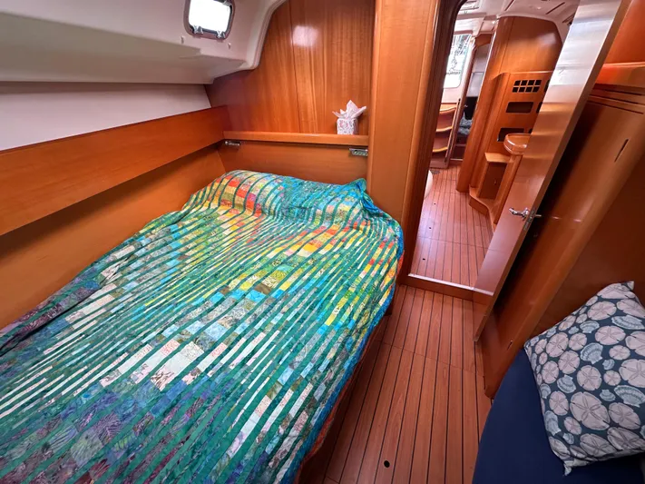 Pacifico Yacht Photos Pics Cozy cabin interior of 2005 Beneteau First 44.7 sailboat with colorful bedding.