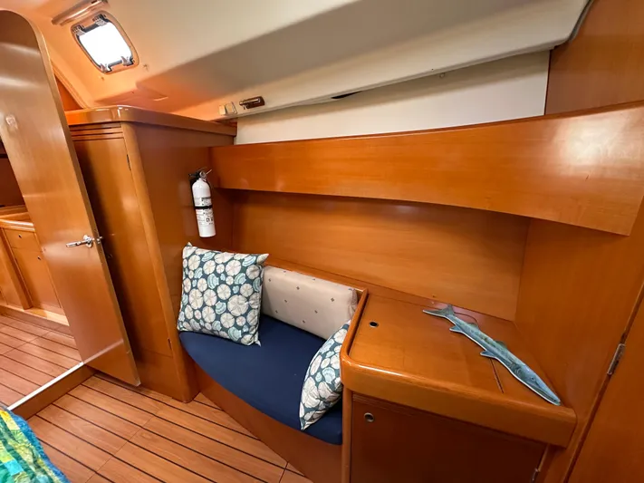 Pacifico Yacht Photos Pics Interior of 2005 Beneteau First 44.7 yacht with wooden finish and cushioned seating.