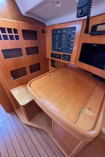 Pacifico Yacht Photos Pics Navigation station of 2005 Beneteau First 44.7 yacht with wooden finish and control panel.