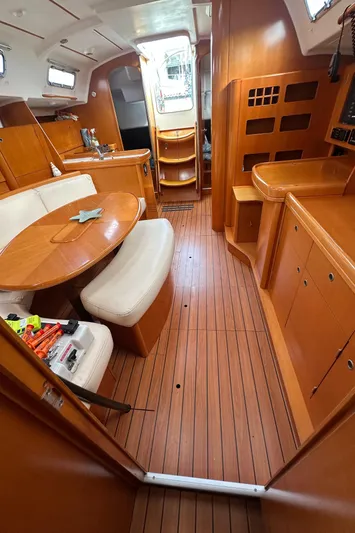Pacifico Yacht Photos Pics Interior of 2005 Beneteau First 44.7 sailboat with wood finish and seating area.