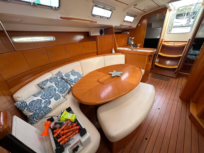 Pacifico Yacht Photos Pics Interior of 2005 Beneteau First 44.7 yacht with wooden finish and cozy seating area.