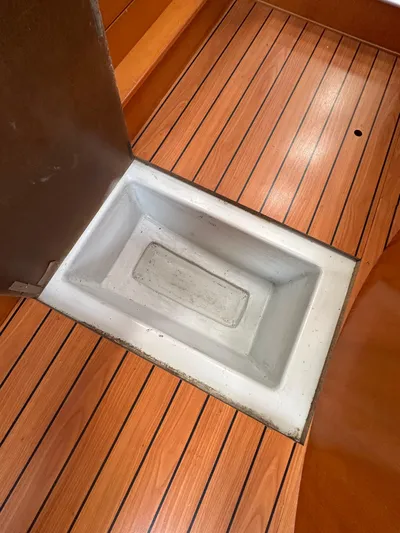 Pacifico Yacht Photos Pics Beneteau First 44.7 (2005) interior with wooden flooring and built-in storage compartment.