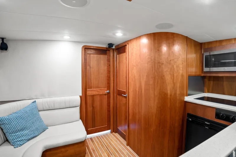 Break Time Yacht Photos Pics 2007 Custom Carolina Layton Express interior with wood cabinetry, white seating, and modern kitchen amenities.