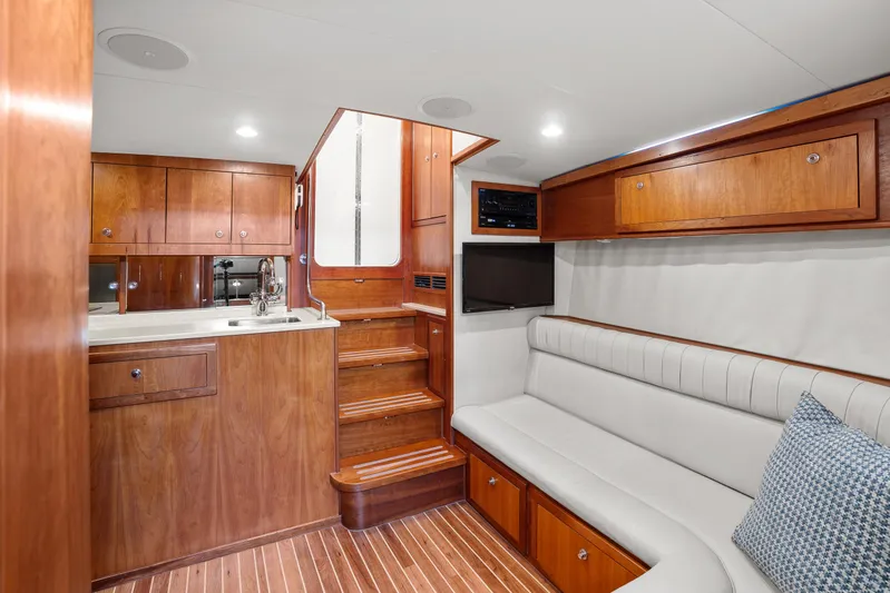 Break Time Yacht Photos Pics Luxurious 2007 Custom Carolina Layton Express yacht interior with wood cabinetry and white seating.
