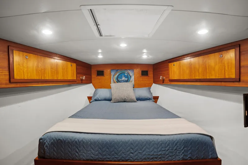 Break Time Yacht Photos Pics Luxurious cabin interior of 2007 Custom Carolina Layton Express with cozy bed and wooden cabinets.