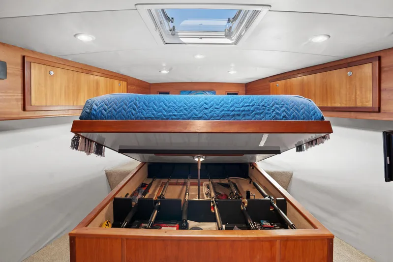 Break Time Yacht Photos Pics 2007 Custom Carolina Layton Express cabin with storage under a blue quilted bed.