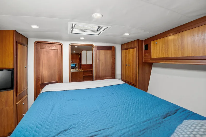 Break Time Yacht Photos Pics 2007 Custom Carolina Layton Express cabin with wood paneling and blue bedding.