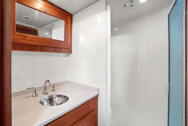 Break Time Yacht Photos Pics Luxurious 2007 Custom Carolina Layton Express bathroom with modern sink and wooden cabinetry.