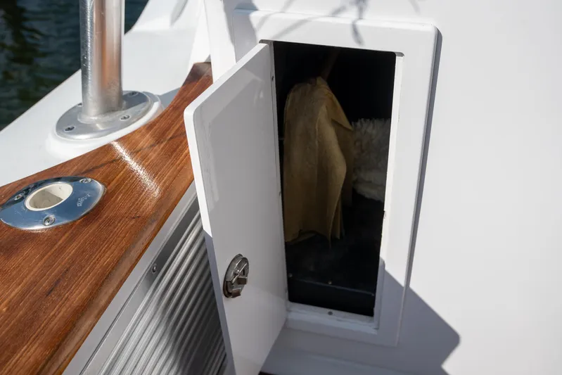 Break Time Yacht Photos Pics Open storage compartment on 2007 Custom Carolina Layton Express boat with wooden trim.