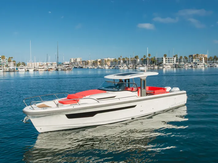 Intrepid Yacht Photos Pics 2021 Nimbus T11 boat with red seating, docked in a marina under a clear blue sky.