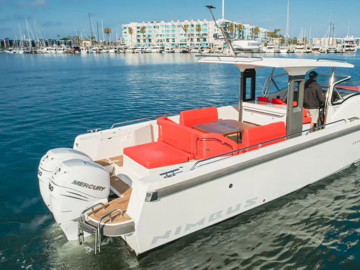 Intrepid Yacht Photos Pics Nimbus T11 2021 boat with red seating, docked in a marina with clear blue water.