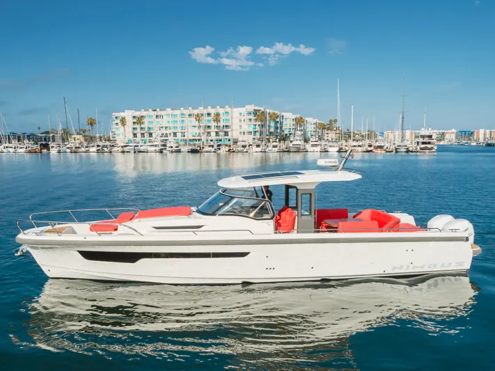 Intrepid Yacht Photos Pics 2021 Nimbus T11 boat with red seating, docked in a marina under clear blue skies.