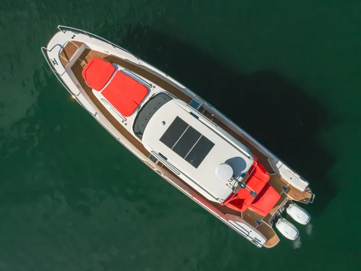 Intrepid Yacht Photos Pics Aerial view of 2021 Nimbus T11 boat with red seating on green water.