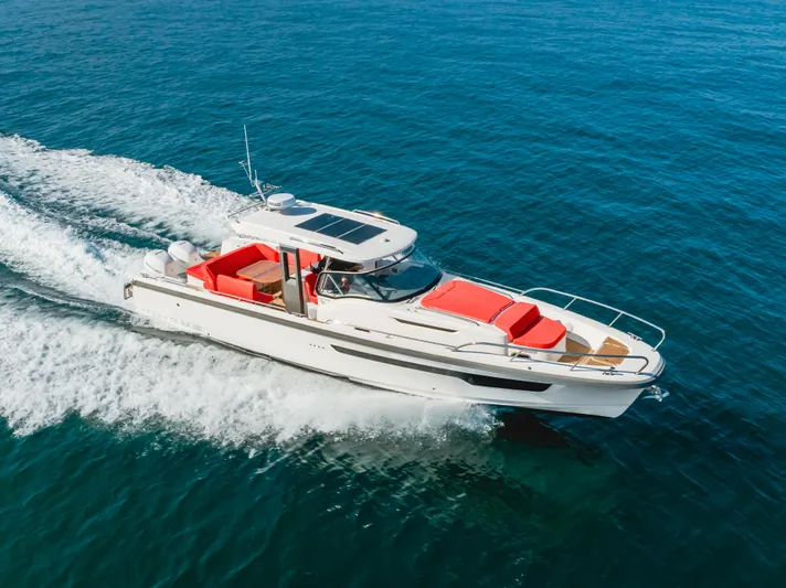 Intrepid Yacht Photos Pics 2021 Nimbus T11 boat cruising on open blue water, featuring red seating.