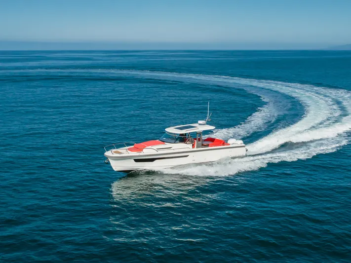 Intrepid Yacht Photos Pics Nimbus T11 2021 motorboat cruising on open blue sea, leaving a curved wake.
