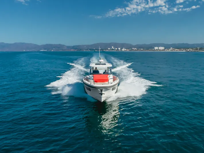 Intrepid Yacht Photos Pics Nimbus T11 2021 motorboat cruising on open sea under clear blue sky.