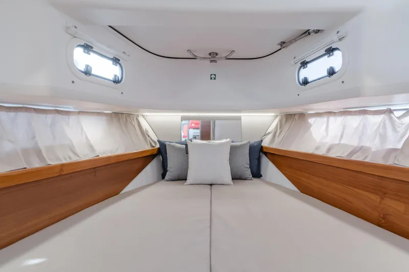 Intrepid Yacht Photos Pics Luxurious interior cabin of 2021 Nimbus T11 boat with cozy bedding and wooden accents.