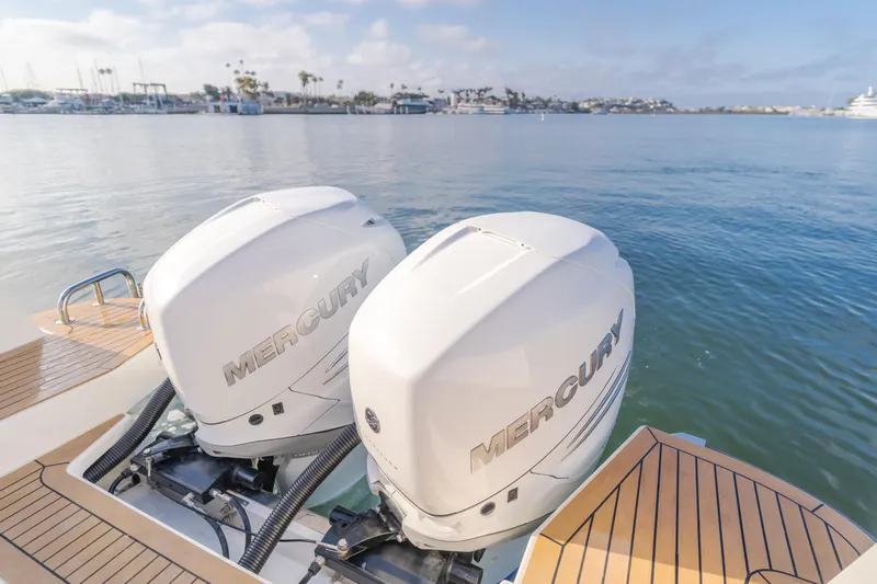 Intrepid Yacht Photos Pics Twin Mercury outboard engines on a 2021 Nimbus T11 boat, docked by a serene waterfront.