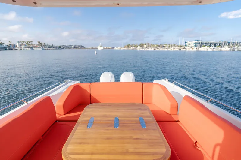 Intrepid Yacht Photos Pics Rear view of 2021 Nimbus T11 yacht with orange seating and wooden table on calm water.